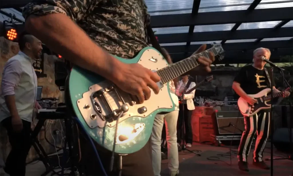 Band playing music and close up of guitar